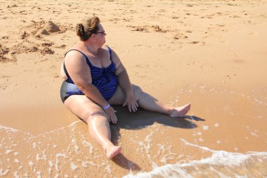 depositphotos_11081534-stock-photo-overweight-woman-sitting-on-beach.jpg