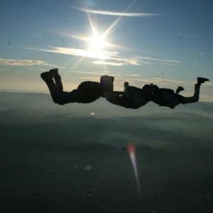 2 other skydivers and I freefalling in front of a declining sun over Perris, California