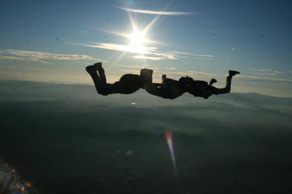 2 other skydivers and I freefalling in front of a declining sun over Perris, California
